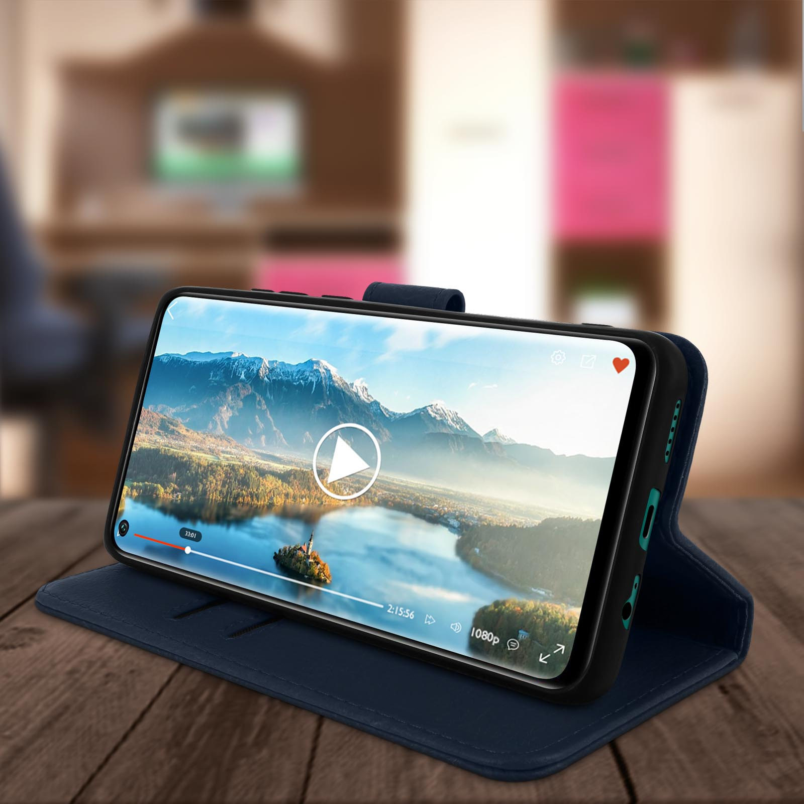 Blauwe leren telefoonhoes met een telefoon die een video afspeelt. Houten tafel op de achtergrond, wazig.