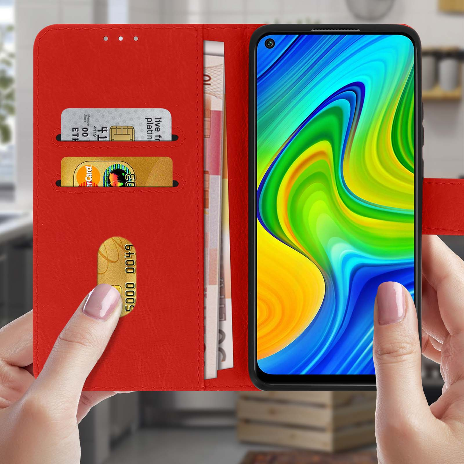 Custodia a portafoglio rossa con telefono e carte, mano di donna che la tiene.