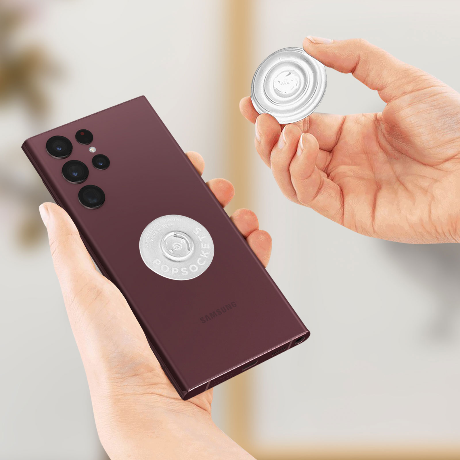 Telefon mit PopSocket befestigt. Hand hält den PopSocket neben dem Telefon.
