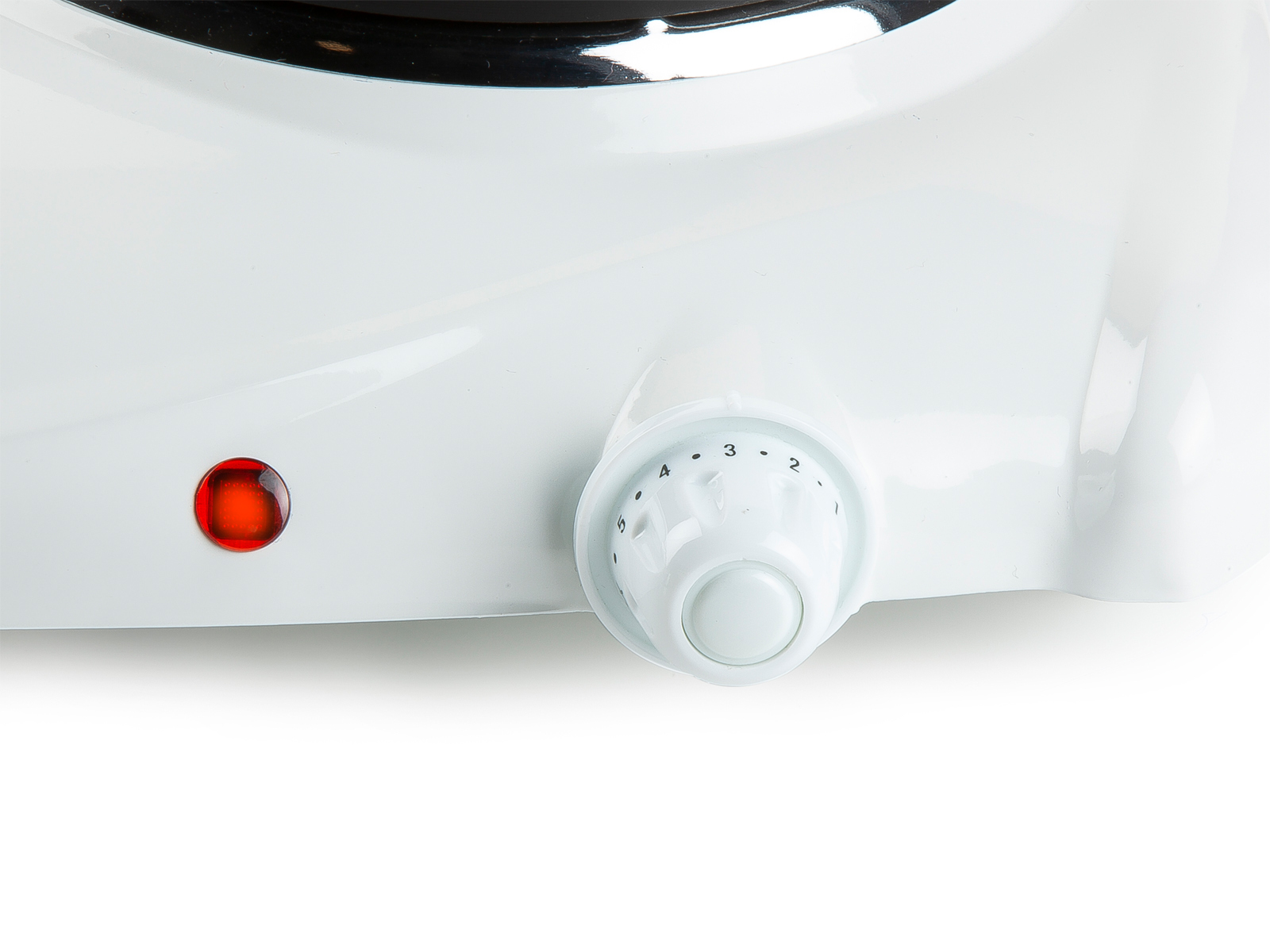 Zbliżenie białego pokrętła sterowania kuchenki elektrycznej.