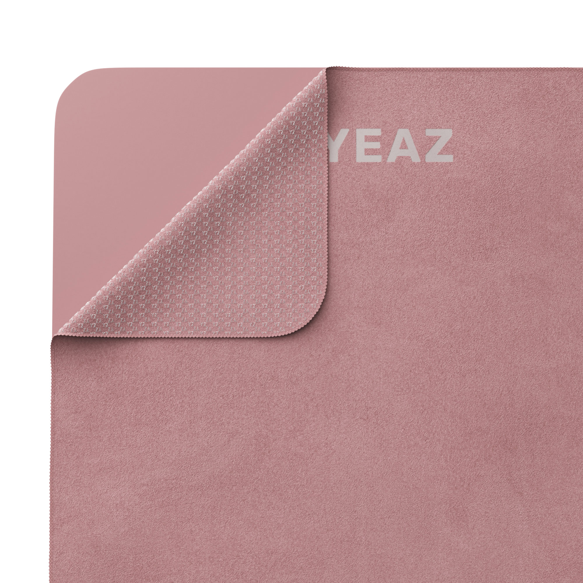 Rosa Yogamatte, deren Ecke zurückgeklappt ist, um die strukturierte Oberfläche der Unterseite zu zeigen.