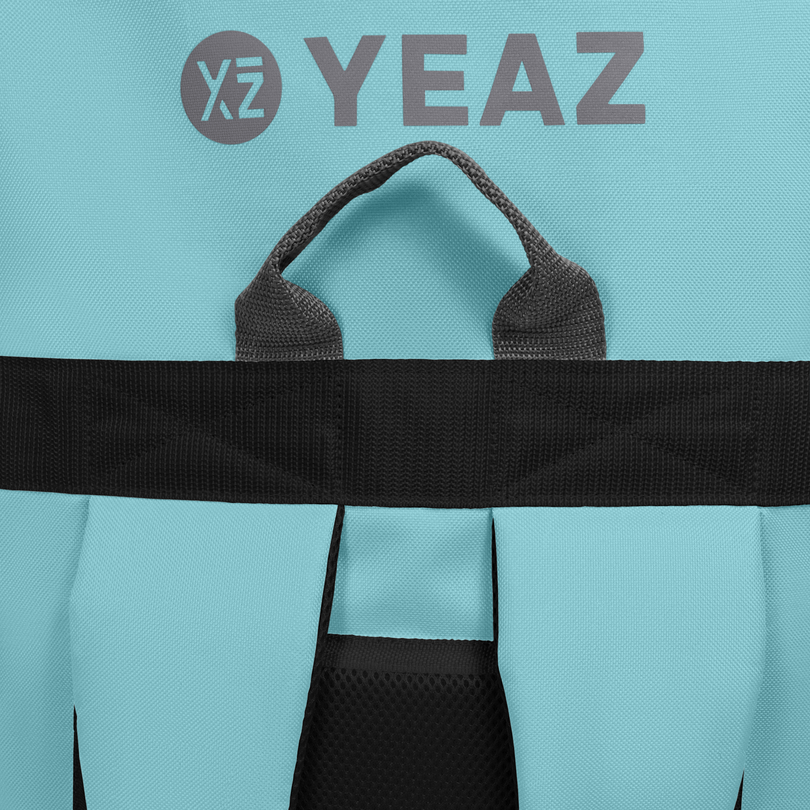 Nahaufnahme eines türkisfarbenen Rucksacks mit schwarzen Trägern und dem Text "XZ YEAZ" in Grau.