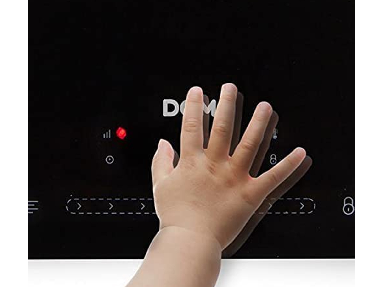 Dłoń dotyka czarnej płyty grzejnej z zapaloną czerwoną kontrolką.