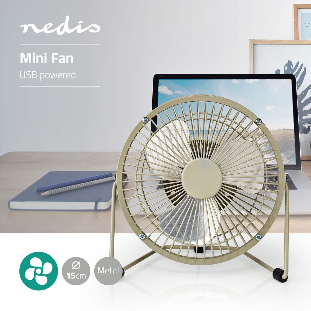 Un piccolo ventilatore in metallo beige su una scrivania accanto a un laptop.