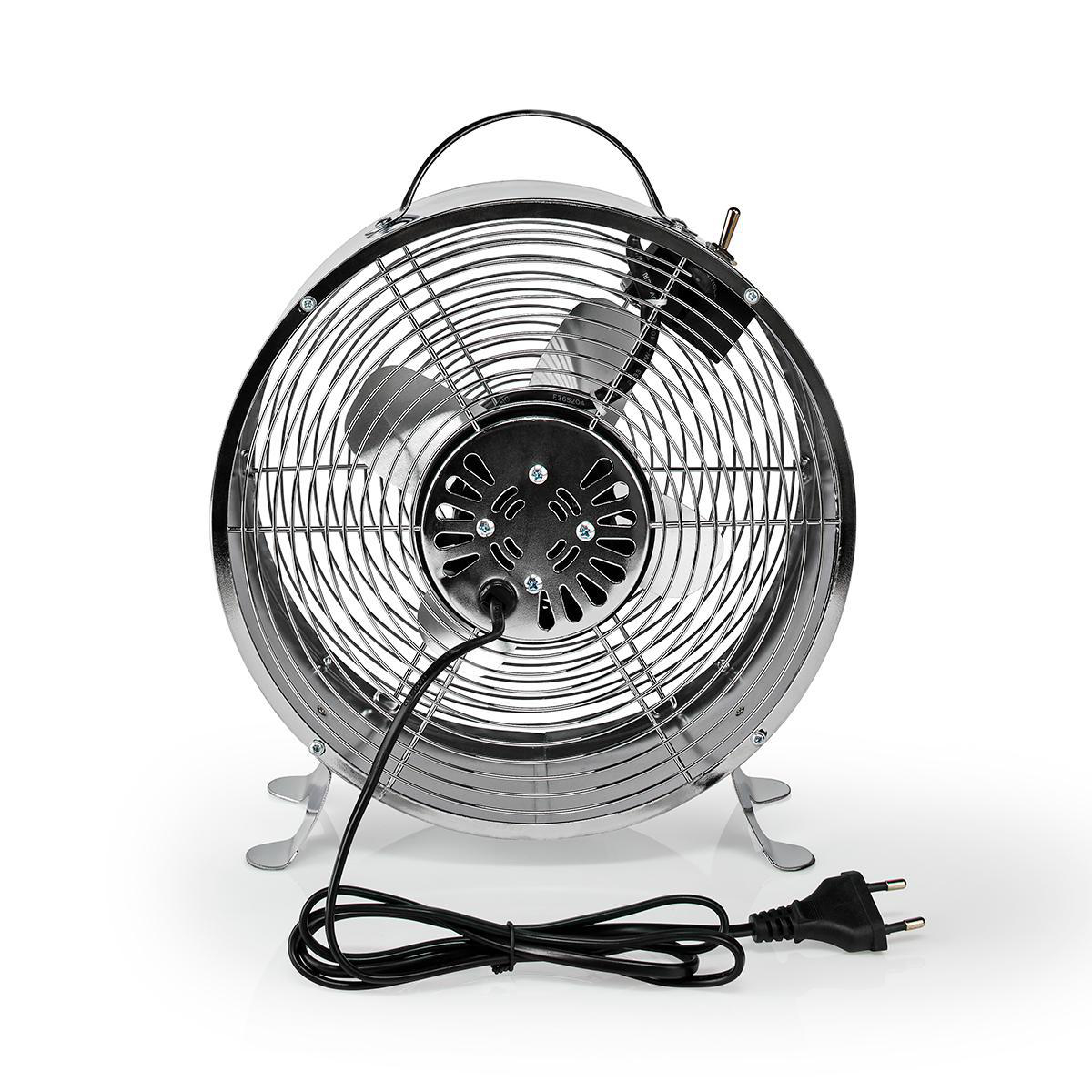Un ventilatore cromato vintage con cavo e spina neri poggia su una superficie bianca.