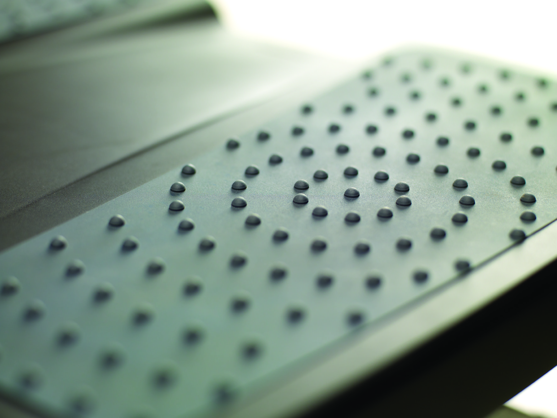 Close-up of a metallic surface with evenly spaced, small, round, gray bumps.