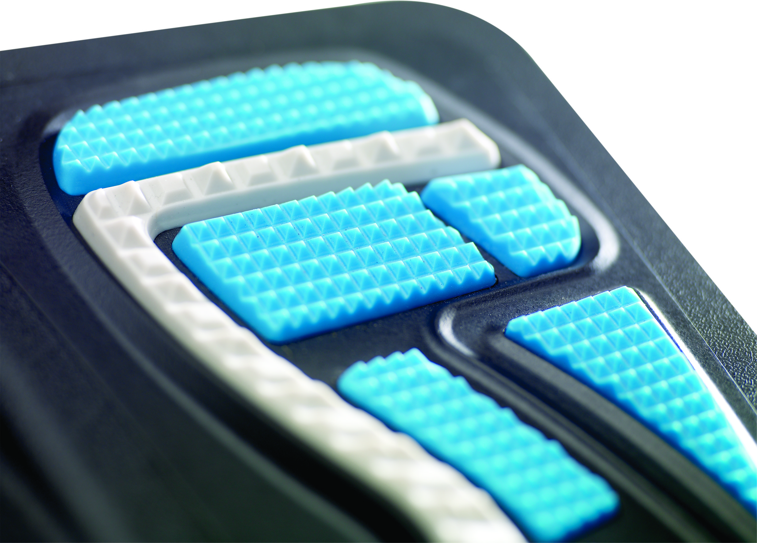 Close-up van een schoenzool met blauwe en witte gestructureerde secties. Donkere achtergrond.