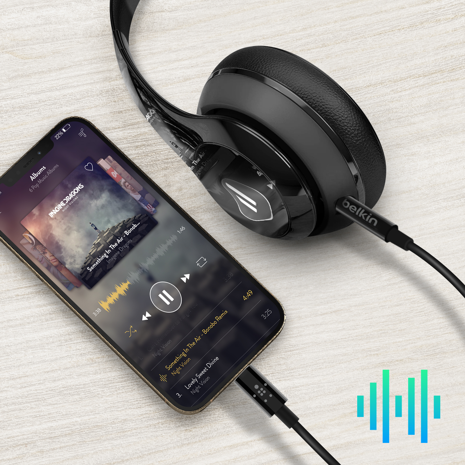 Ein Smartphone mit angeschlossenen Kopfhörern, das eine Musik-App anzeigt. Ein Belkin-Kabel verbindet das Telefon mit den Kopfhörern.