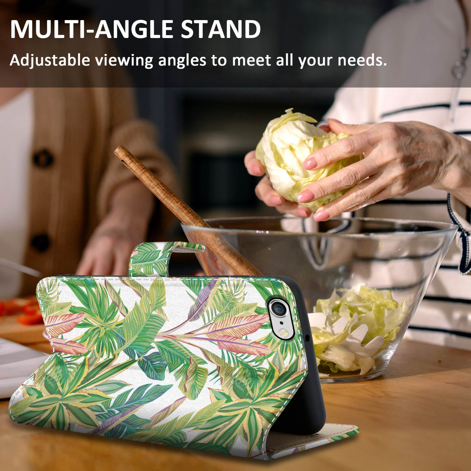 Handyhülle mit Blumendesign auf einem Tisch. Eine Frau bereitet im Hintergrund Salat zu.