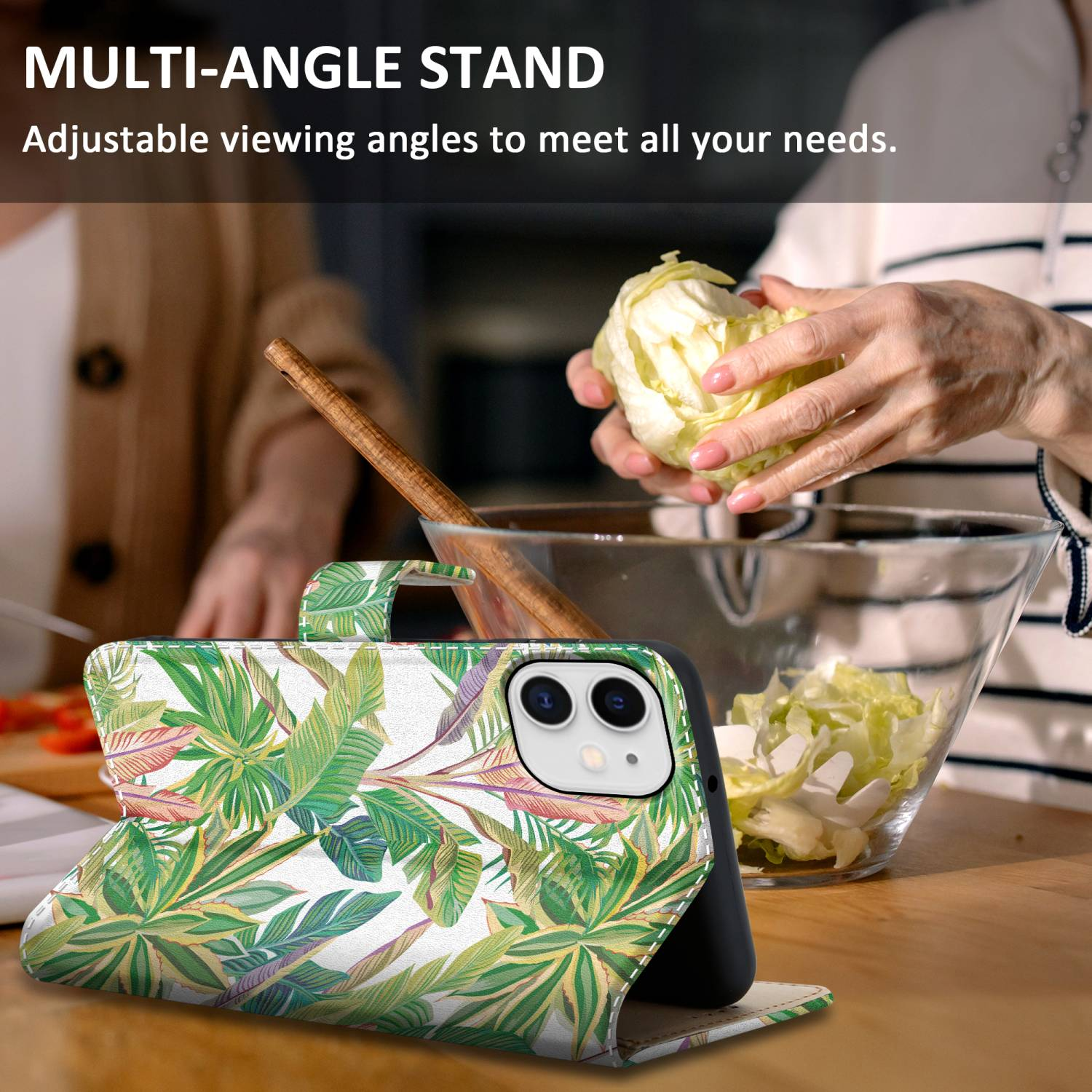 Ein Telefon in einem floralen Etui liegt auf einem Tisch. Im Hintergrund bereitet eine Person Essen zu.