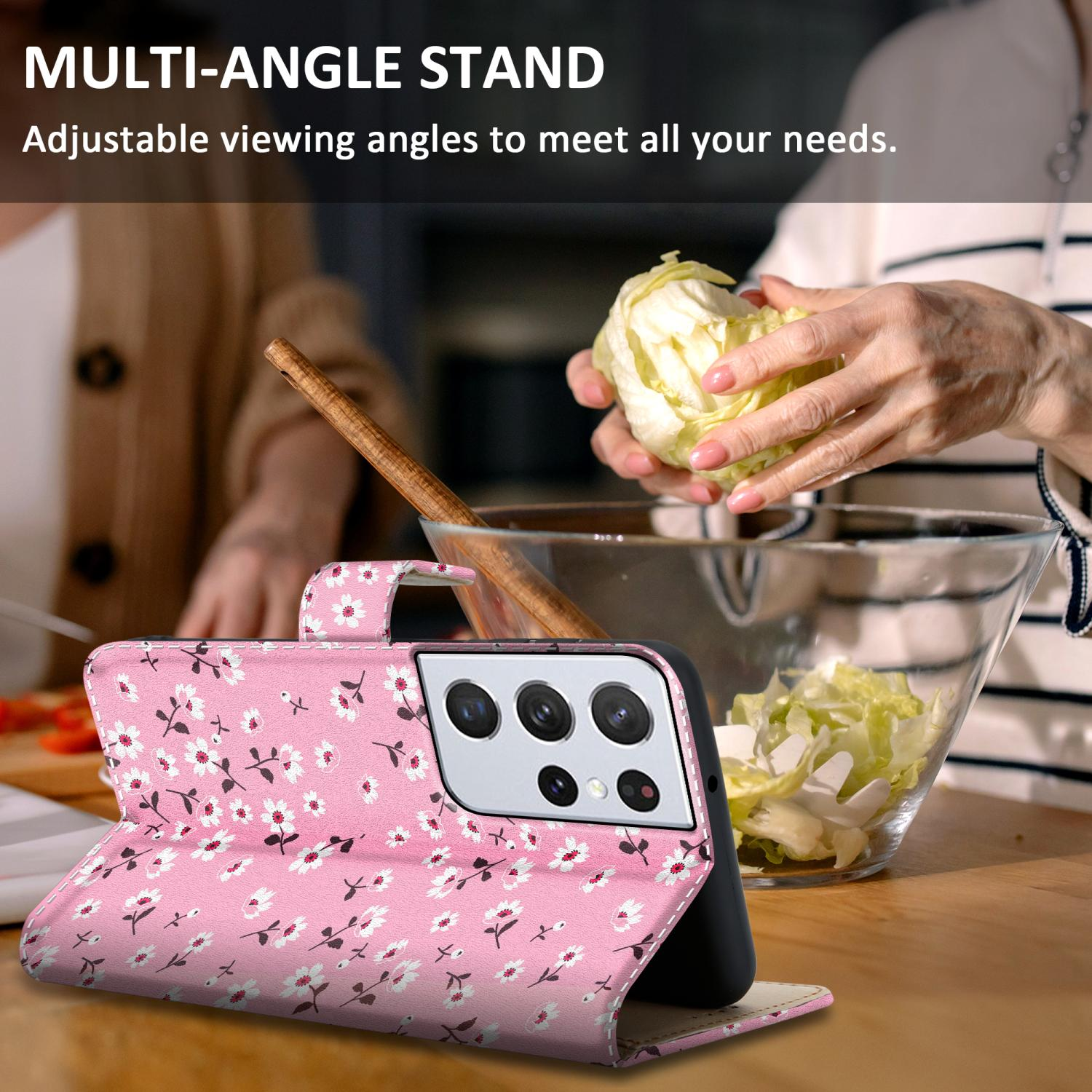 Un telefono in una custodia floreale rosa è su un tavolo accanto a una persona che prepara il cibo, mostrando la funzione del supporto multi-angolo.