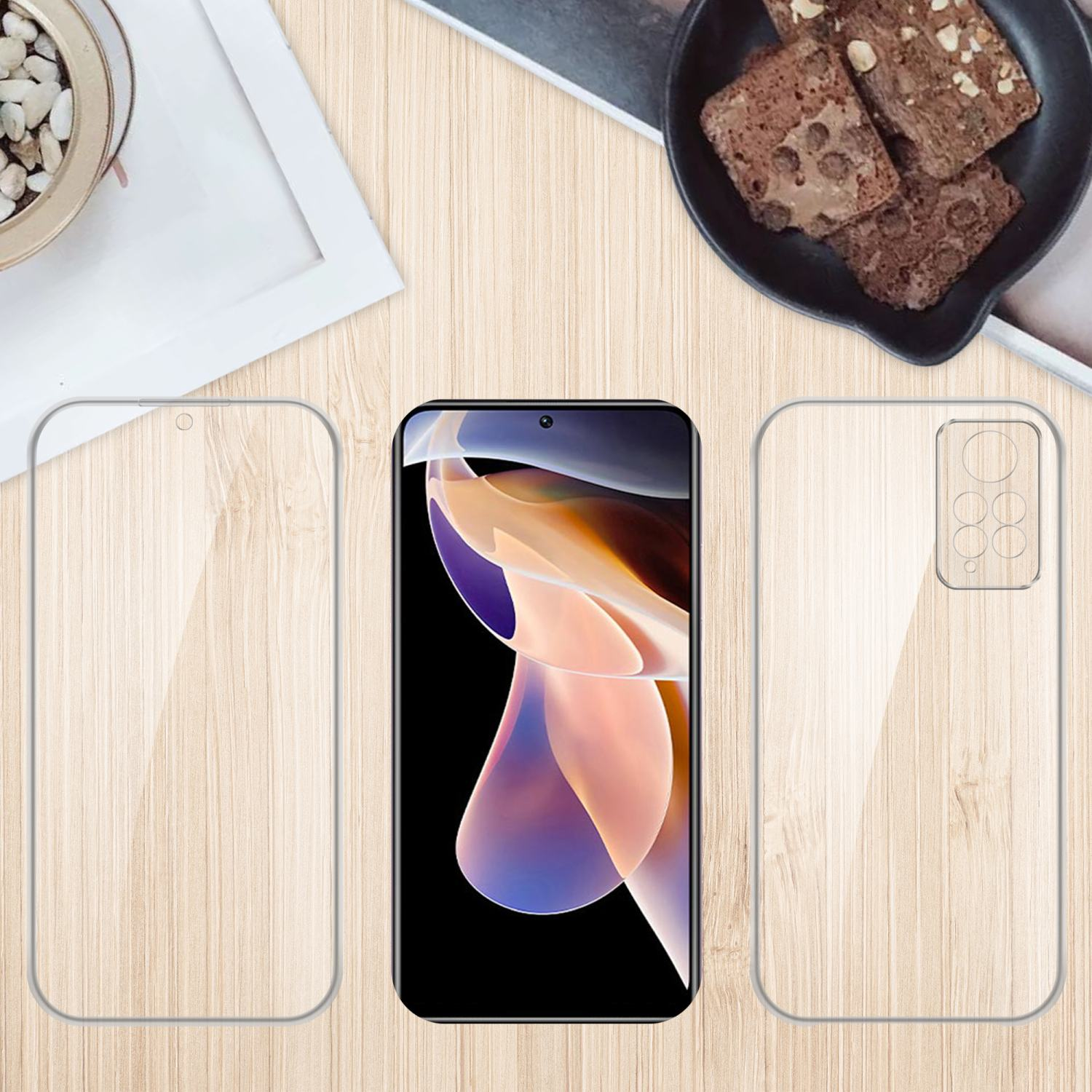 Telefono con protezione schermo, custodia trasparente e accessori su un tavolo di legno. Brownies.