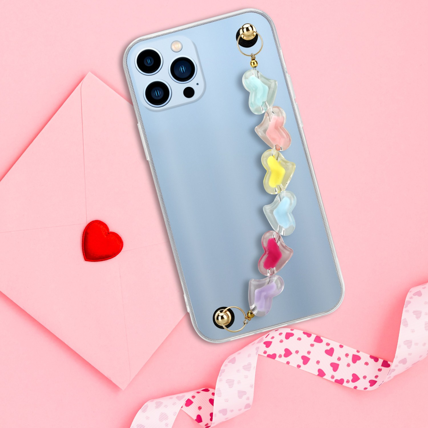 Ein hellblaues Telefon mit buntem herzförmigen Riemen liegt auf rosa Hintergrund mit Herzen.