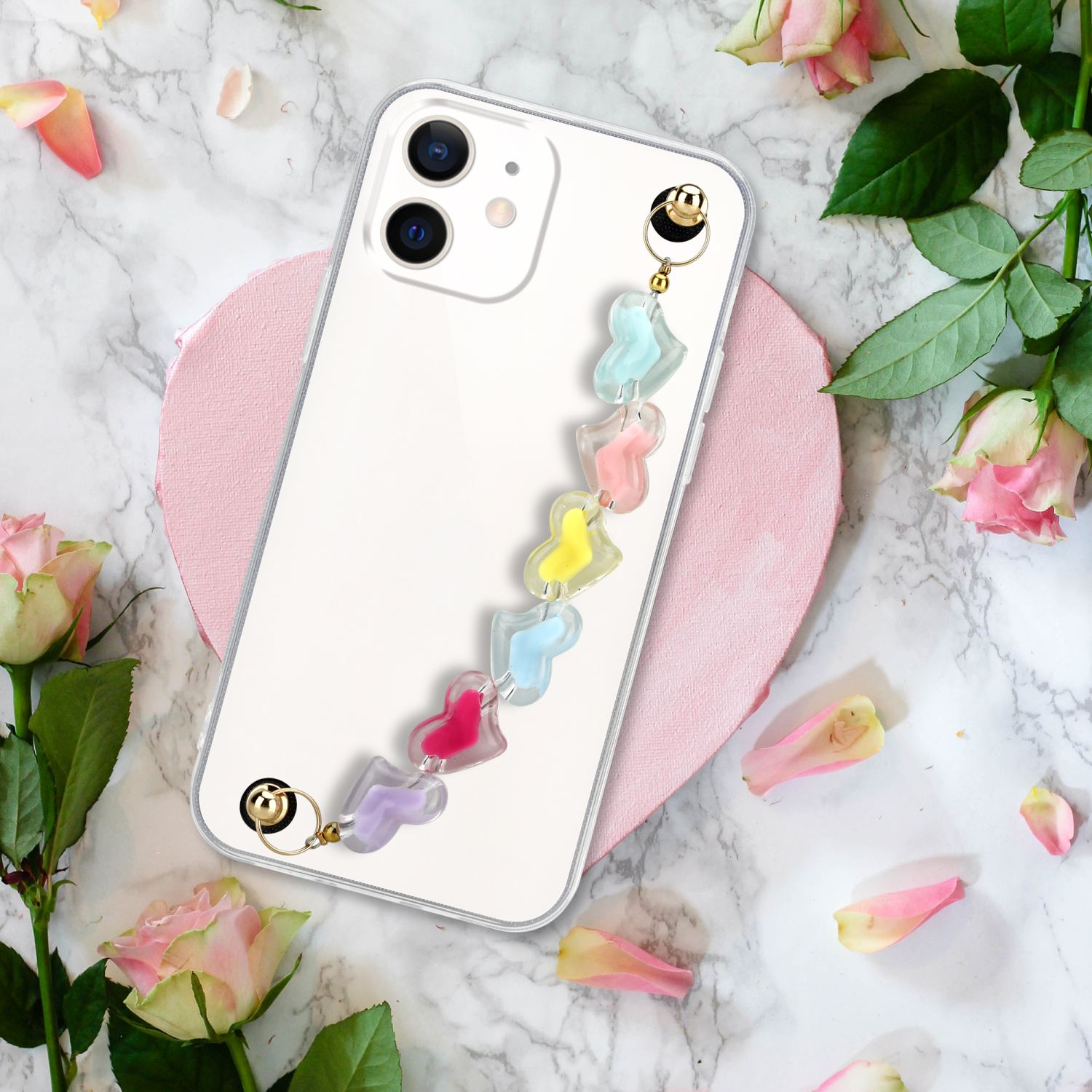 Telefon mit klarer Hülle, mit Herzriemen, auf Marmoroberfläche.