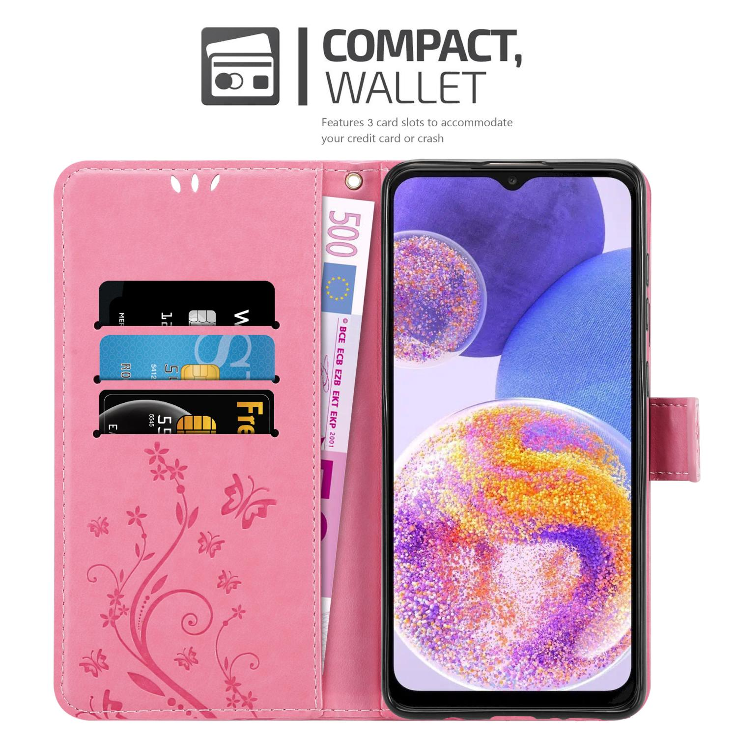Custodia a portafoglio rosa per telefono, aperta che mostra telefono, carte e denaro. Caratterizzata da un design floreale.