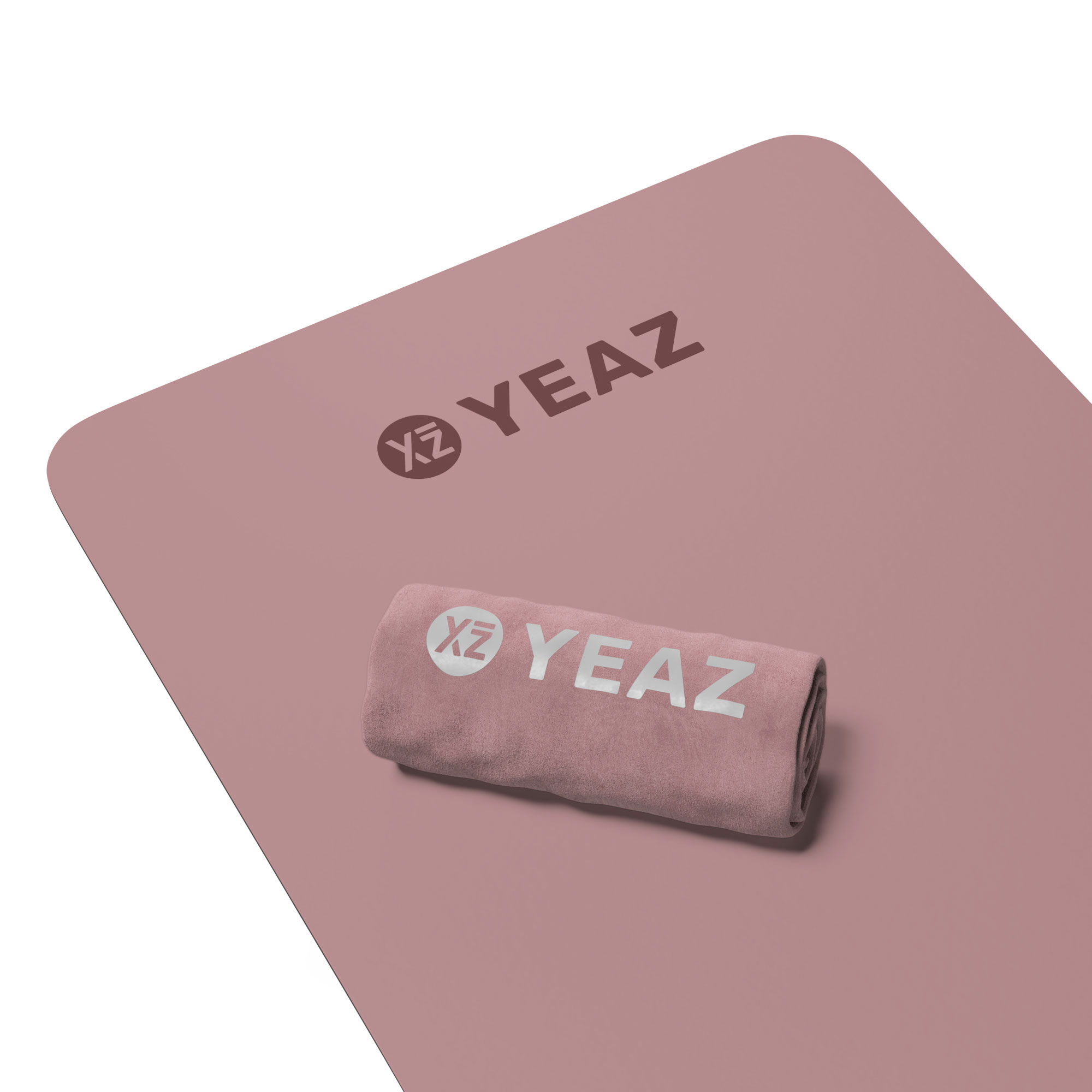 Rosa Yogamatte und gerolltes Handtuch mit Logo. Matte und Handtuch sind im Studio.