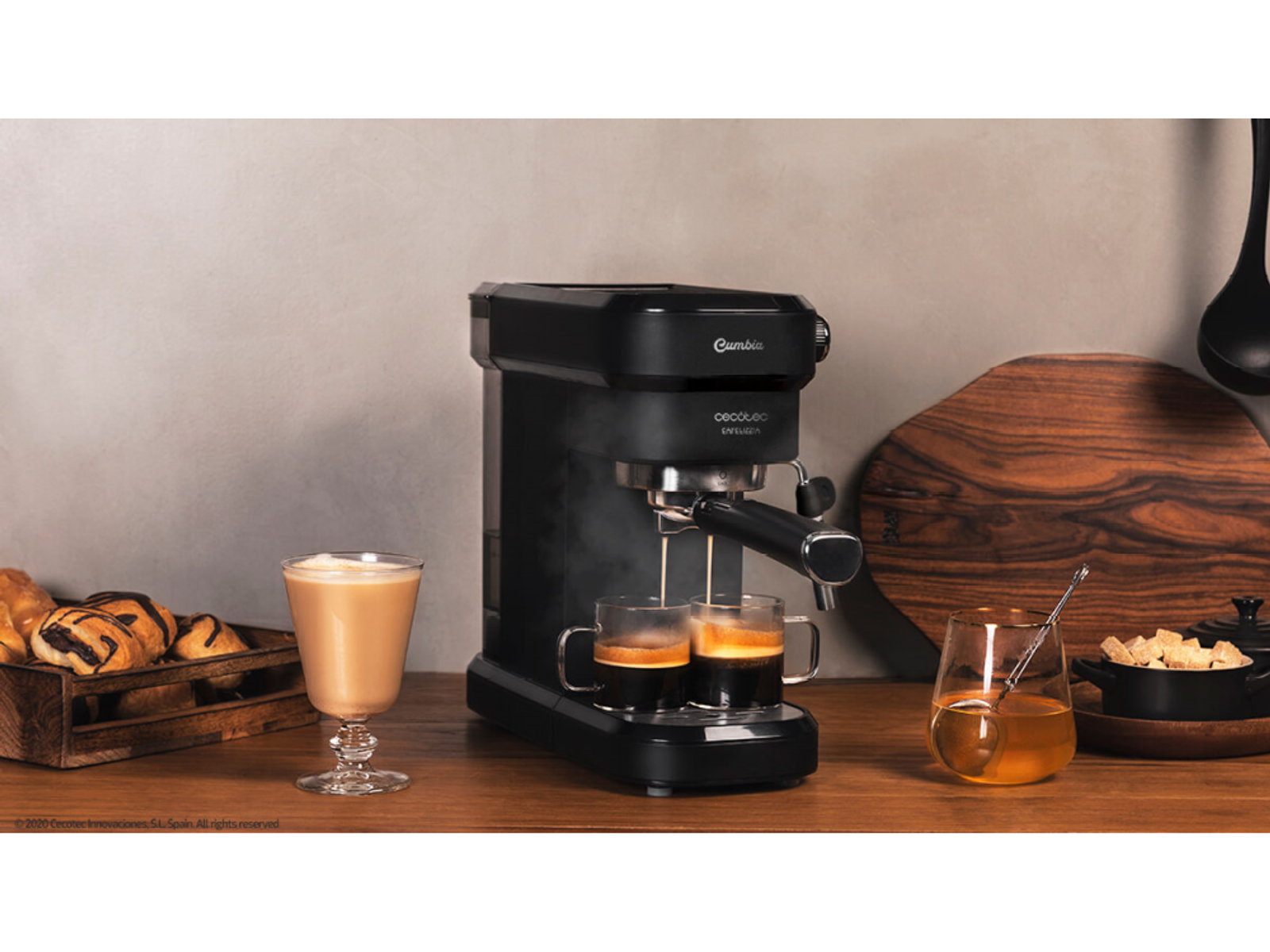 Czarny ekspres do kawy z dwiema szklankami kawy i innymi przedmiotami na drewnianym stole. Szklanka latte.