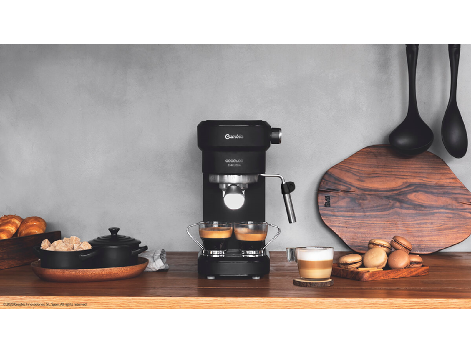 Czarny ekspres do espresso. Dwa kieliszki z espresso. Drewniana deska do krojenia i drewniany stół.