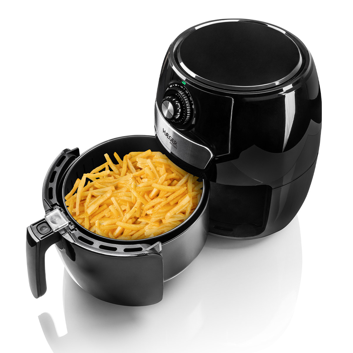Friggitrice ad aria nera con cestello aperto pieno di patatine fritte su superficie bianca.