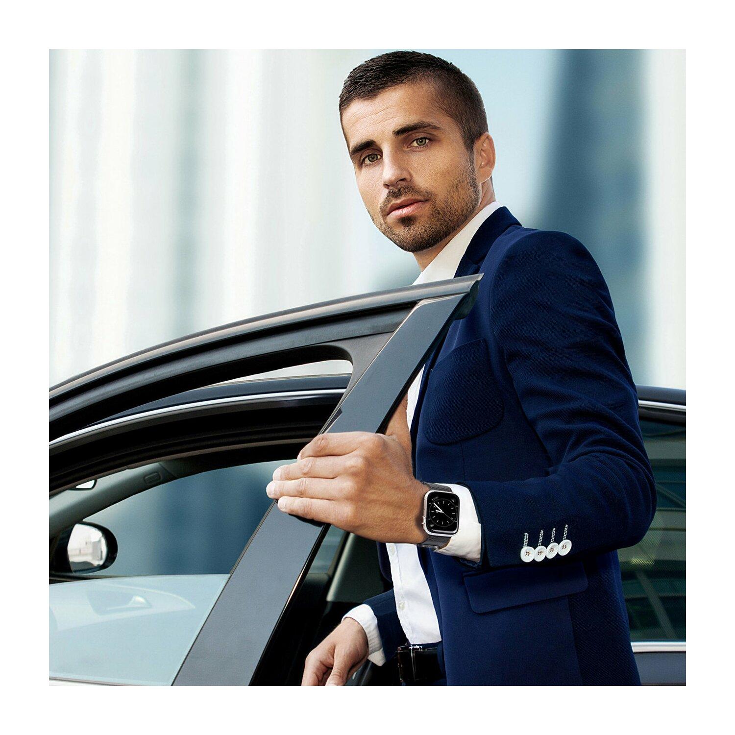 Mann im blauen Anzug steigt aus dem Auto und trägt eine Uhr. Stadt-Hintergrund ist verschwommen.