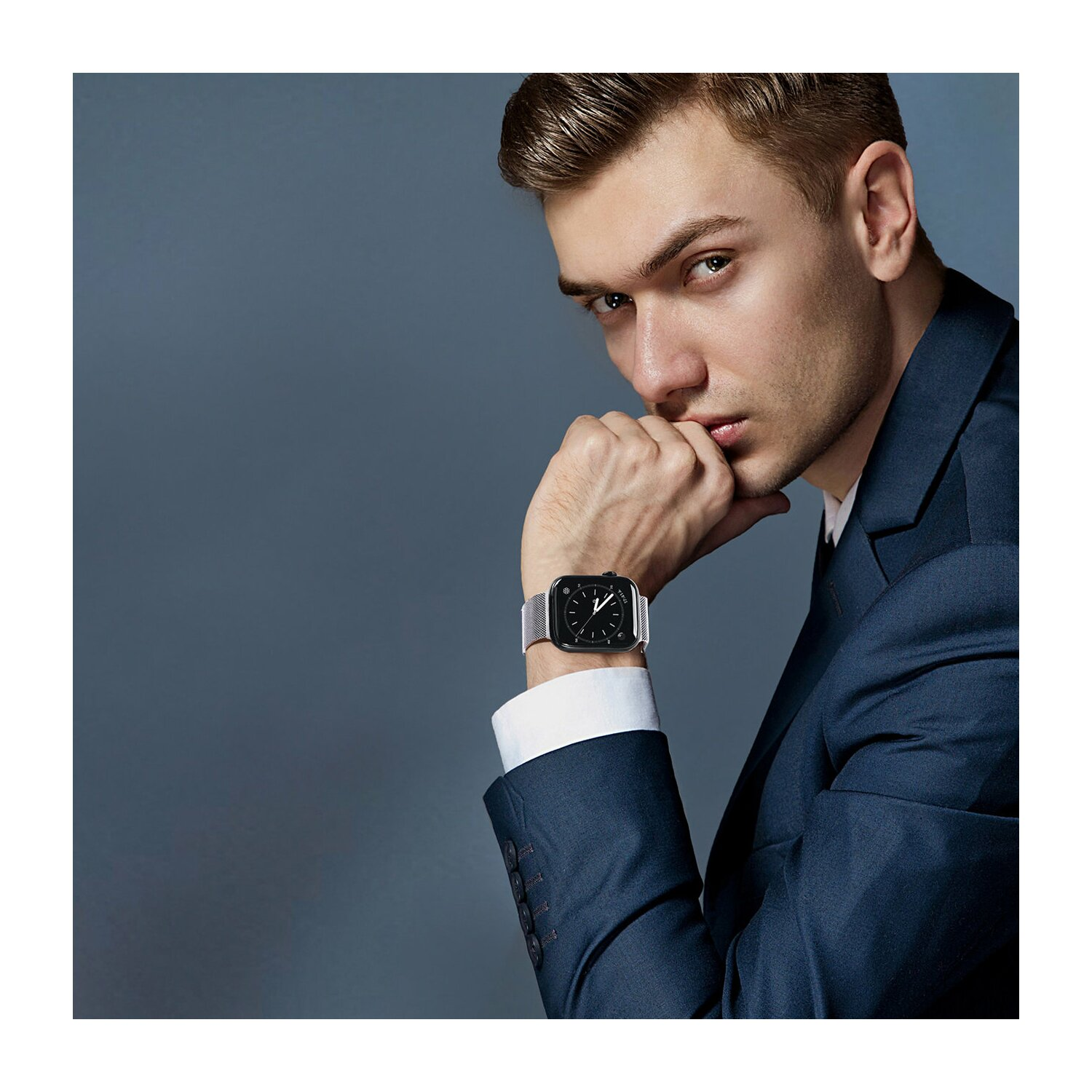Mann im Anzug mit Smartwatch, schaut in die Kamera.