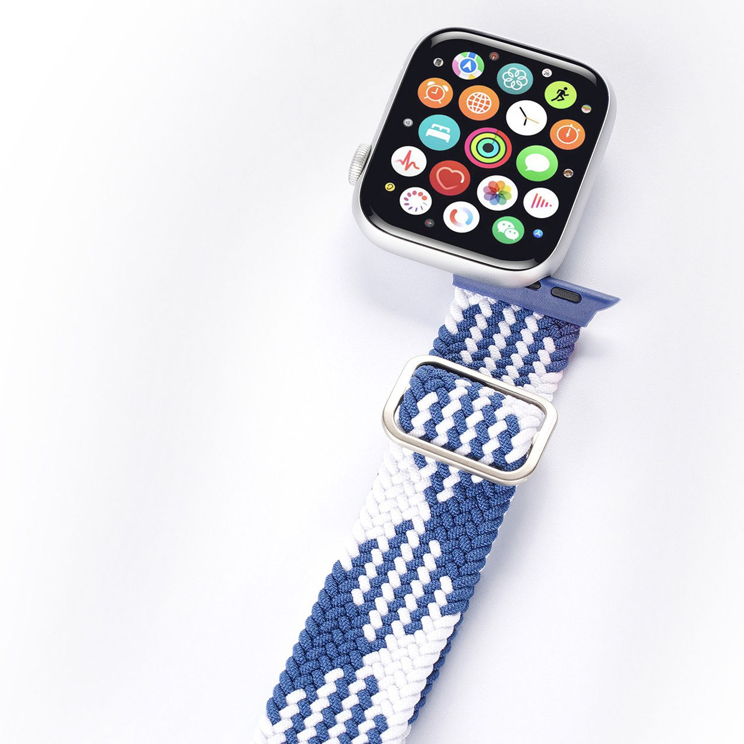 Apple Watch mit blau-weiß gestreiftem Armband auf weißer Oberfläche.