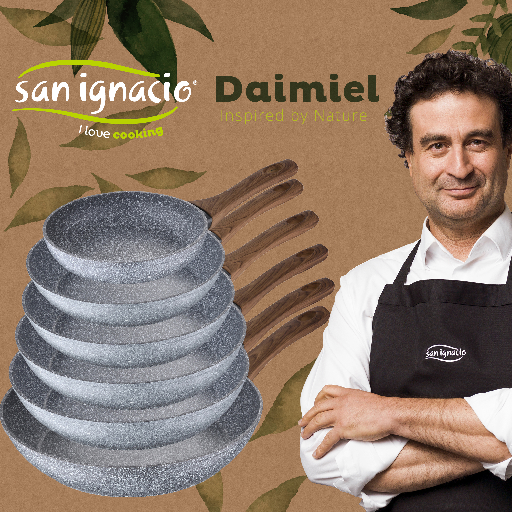 Un hombre con un delantal negro está junto a una pila de sartenes. Las sartenes tienen mangos de madera.