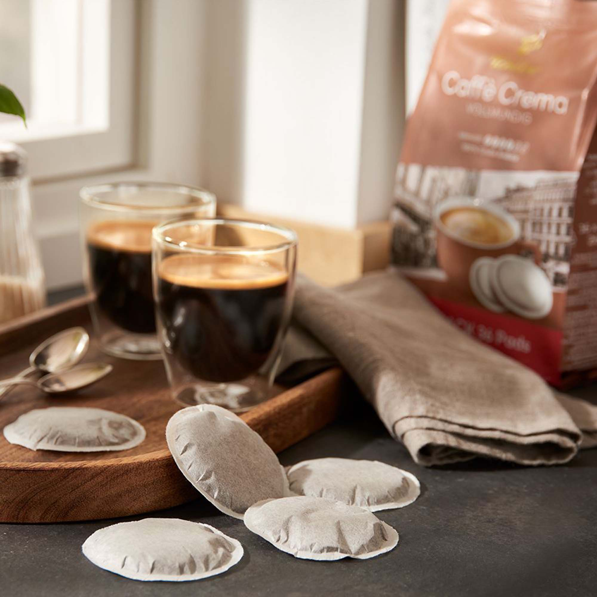 Zwei Kaffeegläser, Kaffeepads und eine Tüte.