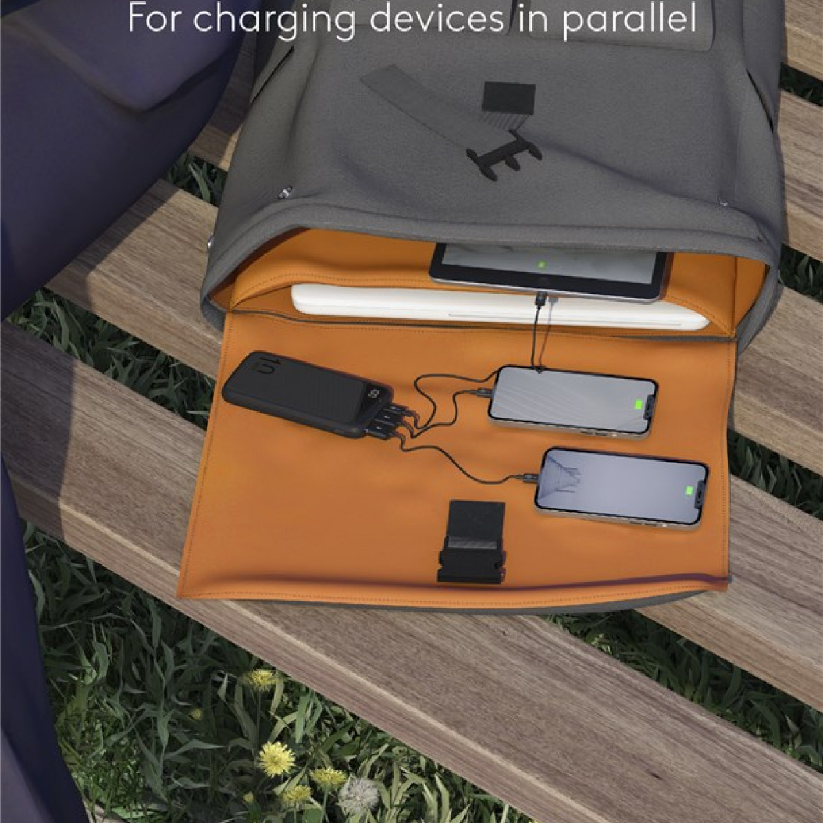 Open rugzak met oplaadapparaten. Telefoons en tablet aangesloten op een powerbank.