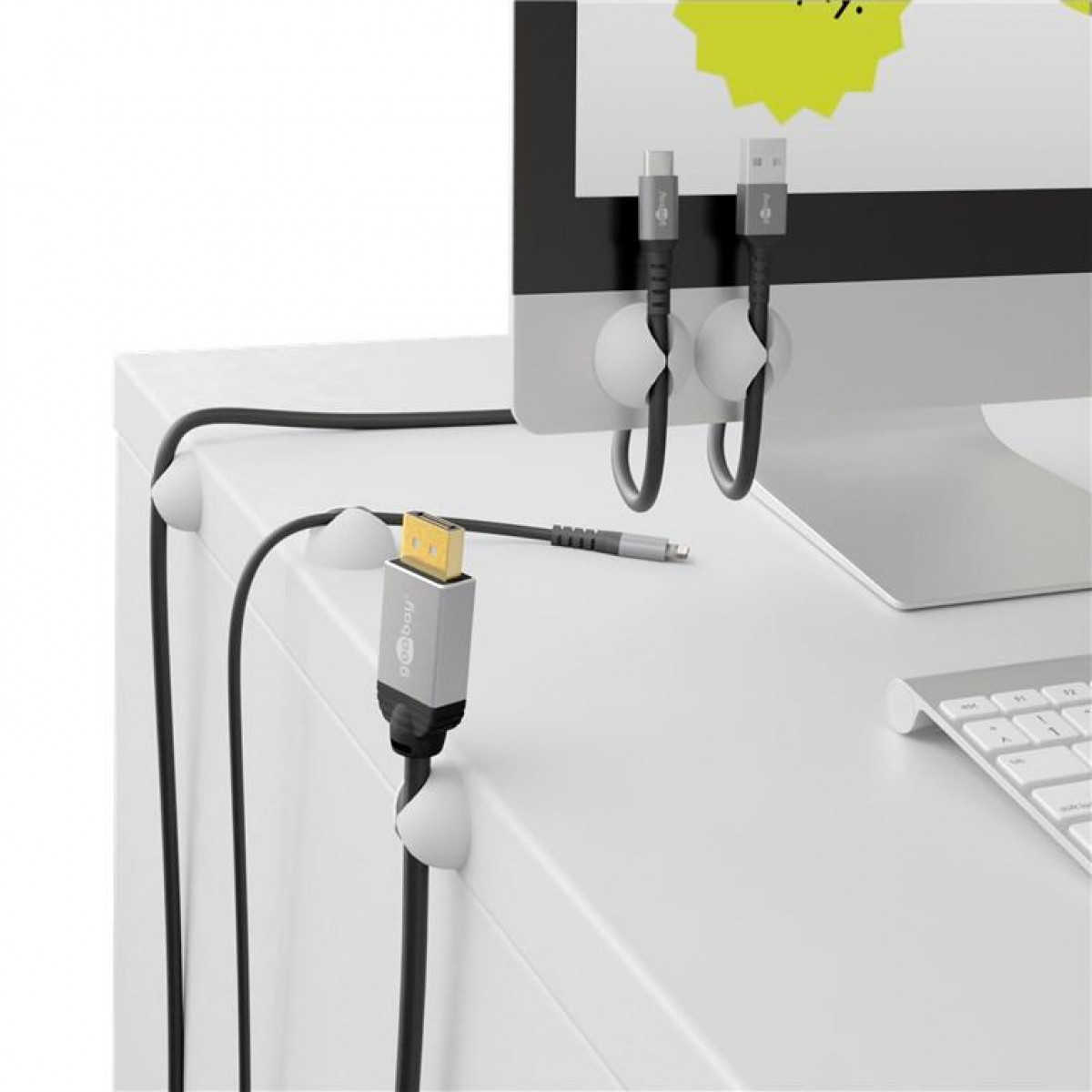 Weißer Schreibtisch mit Kabeln und einem angeschlossenen Monitor. USB- und HDMI-Kabel sind sichtbar.