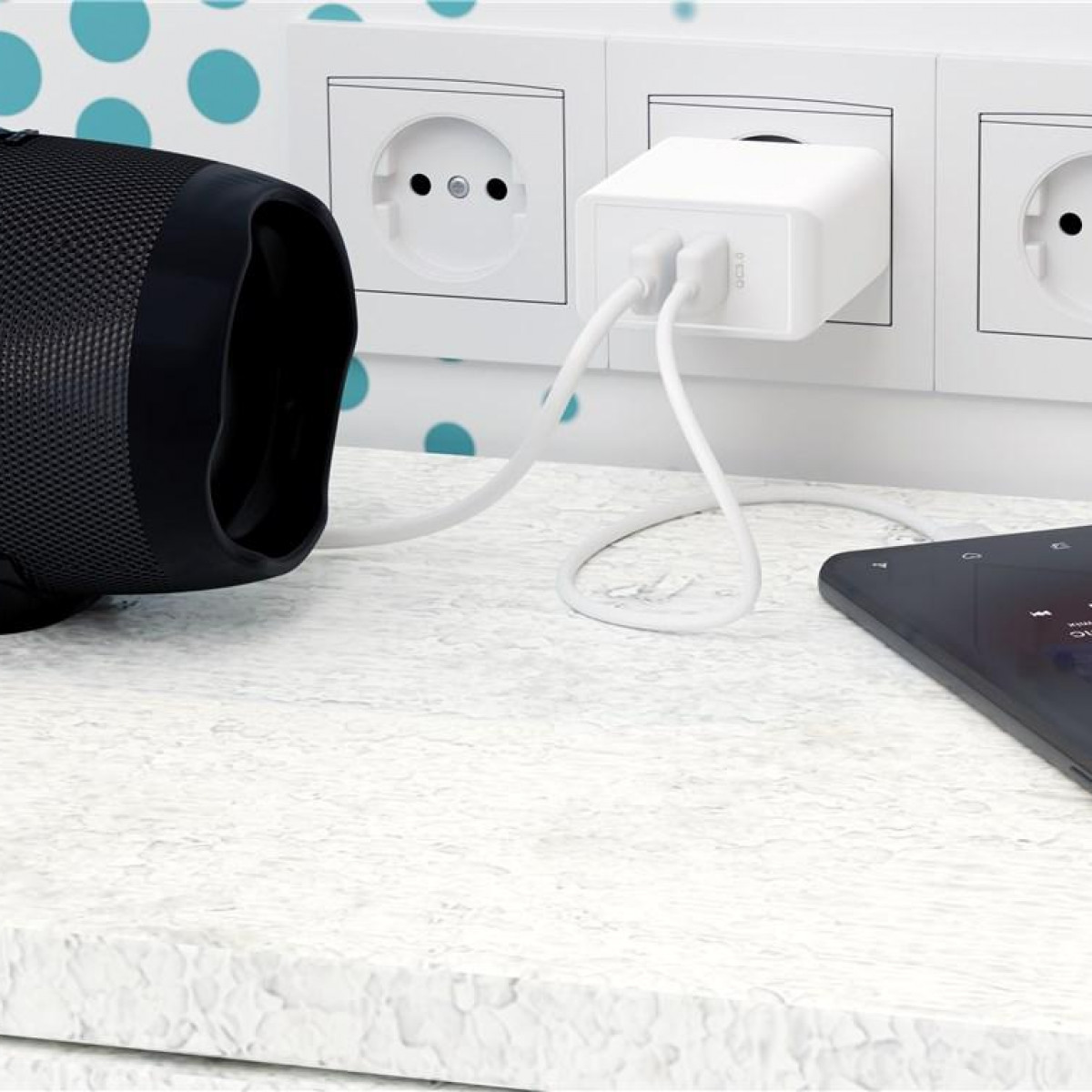 Weißes Ladegerät, weiße Kabel, schwarzes Telefon lädt. Weiße Wand mit Steckdosen und blauen Punkten.