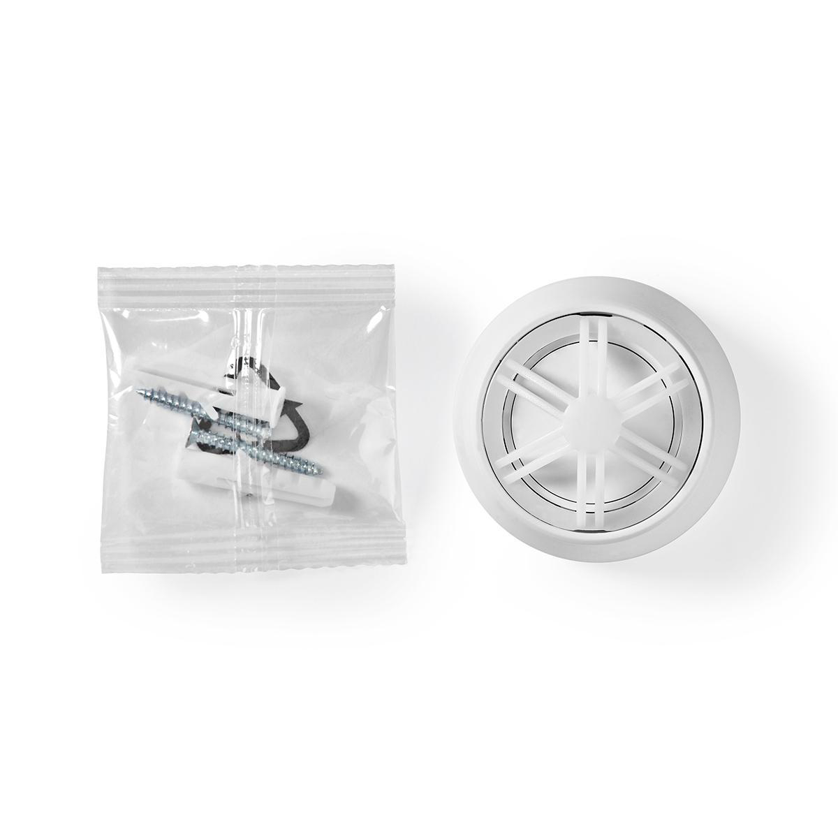 A smoke detector and screws in a plastic bag, both on white background.