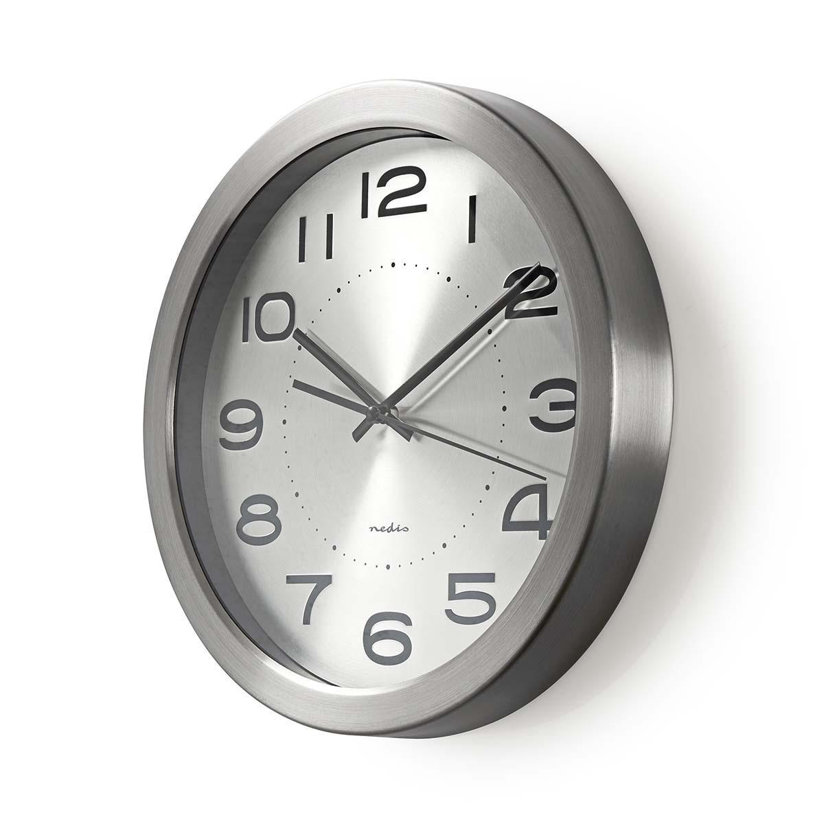 Silberne Uhr mit schwarzen Ziffern und Zeigern. Die Marke ist nedis. Die Uhr ist an der Wand.
