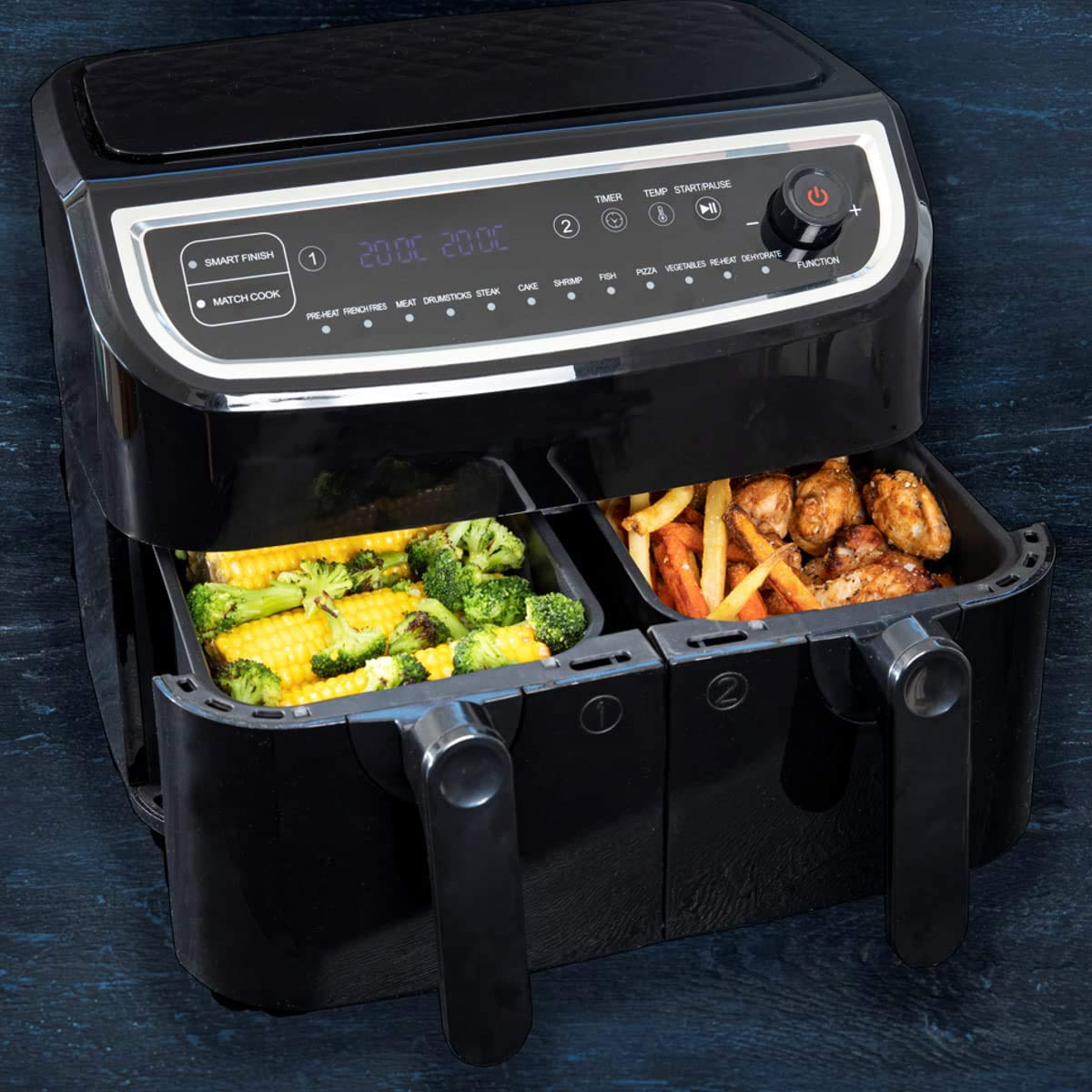 Czarna frytkownica beztłuszczowa z podwójnymi komorami, jedną z kukurydzą i brokułami, drugą z frytkami i kurczakiem.