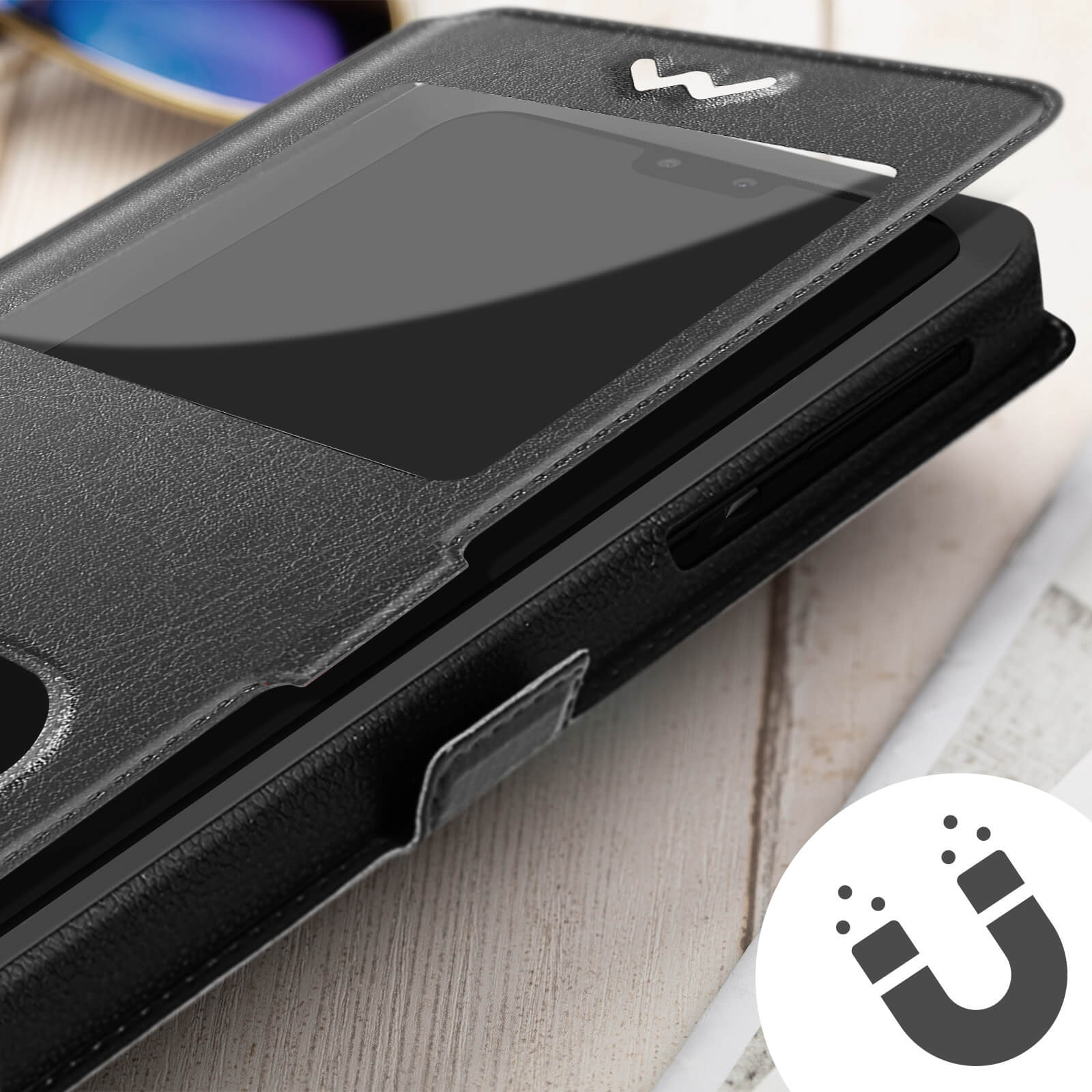 Una custodia per telefono nera con finestra e simbolo del magnete su una superficie di legno.