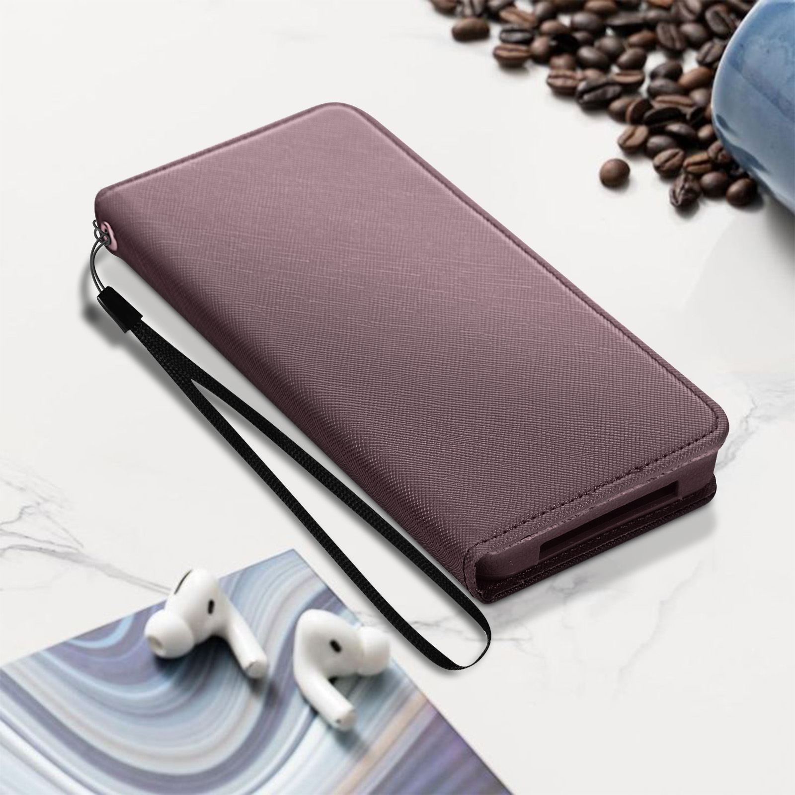Custodia per telefono viola con cinturino nero e auricolari bianchi. Lo sfondo è sfocato con chicchi di caffè.