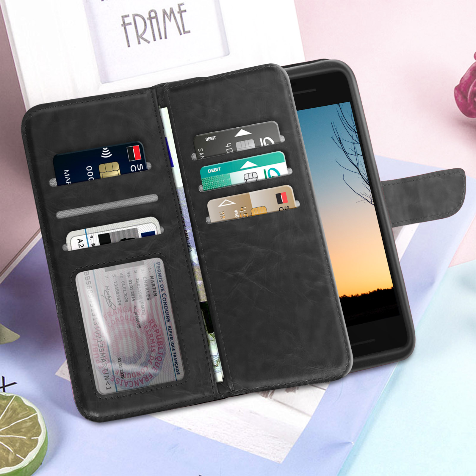 Un portafoglio nero con telefono dentro, carte e documenti. È su un tavolo.