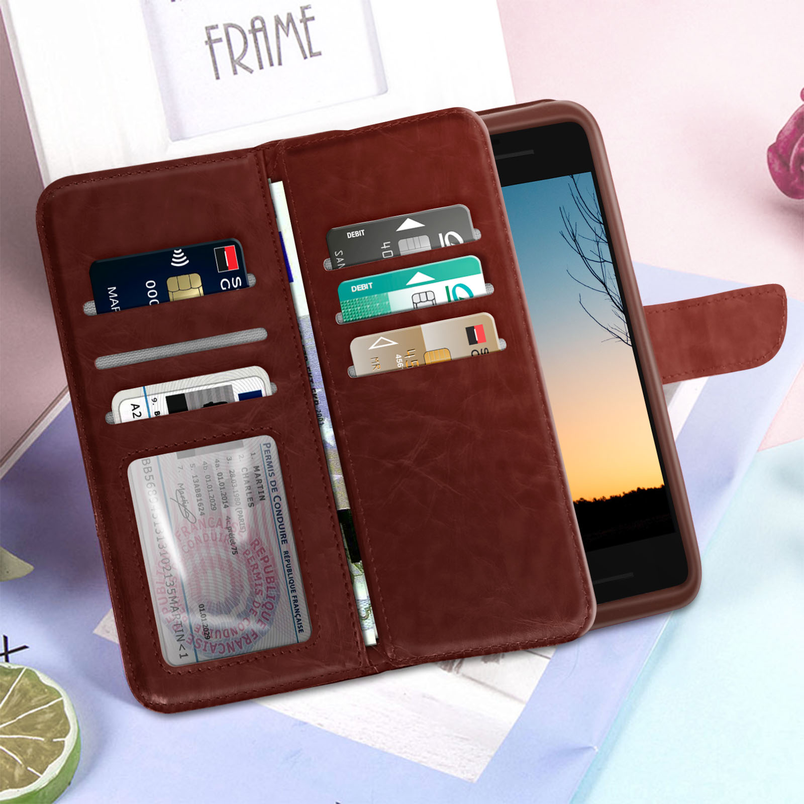 Un portafoglio marrone con carte e un telefono su una scrivania.
