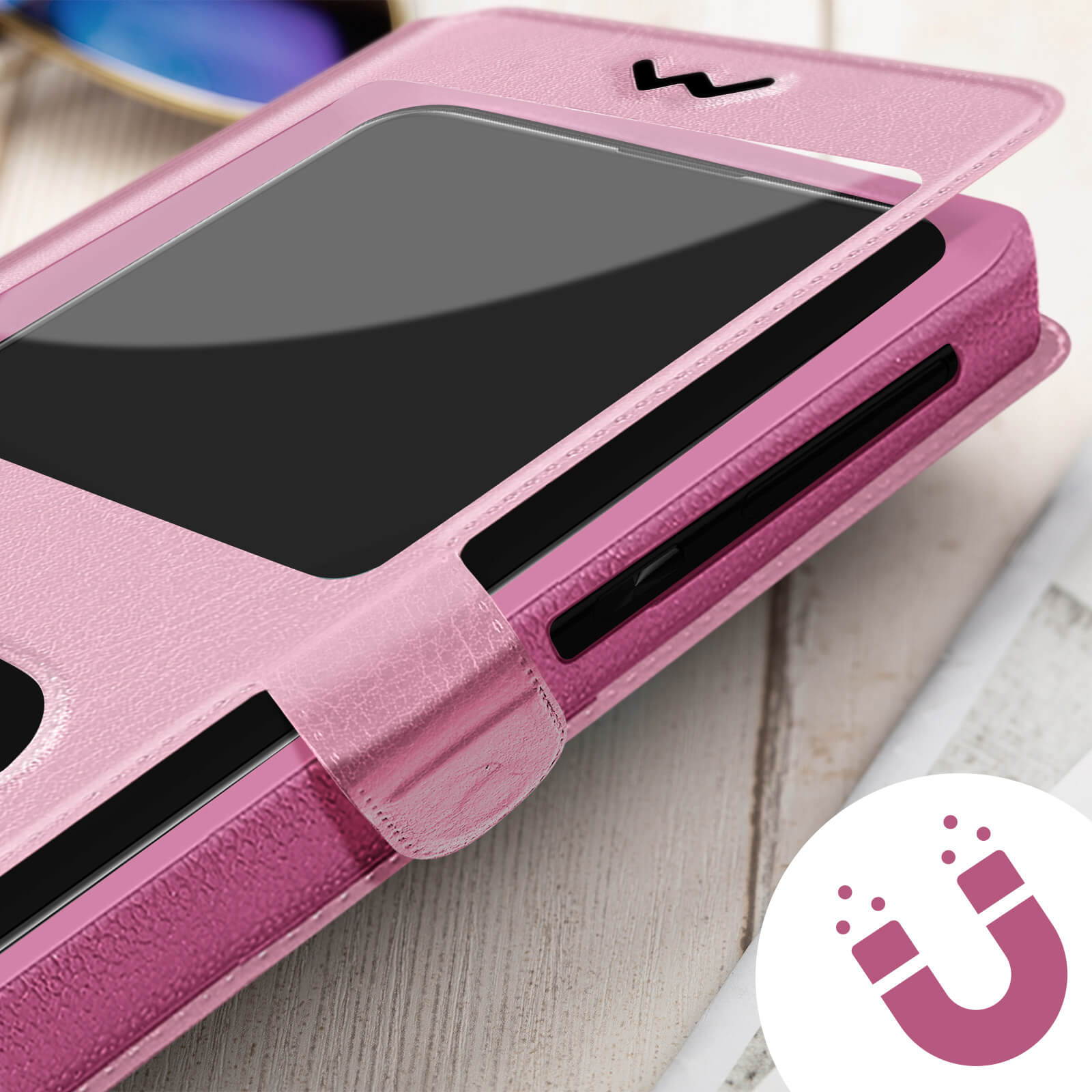 Coque de téléphone rose avec téléphone noir à l'intérieur, ouverte. Une icône d'aimant est visible. Flou.
