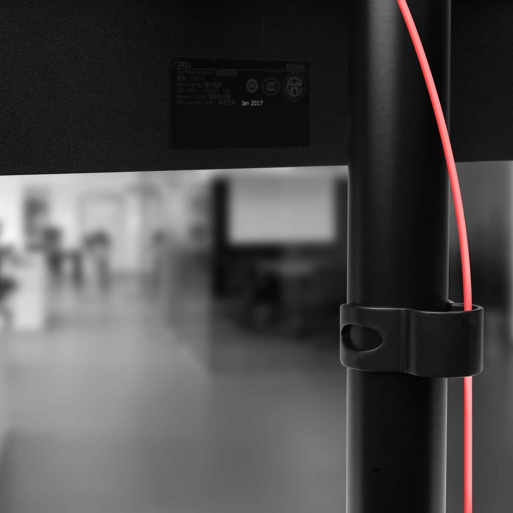 Schwarzer Monitorständer mit rotem Kabel. Dell-Logo sichtbar.