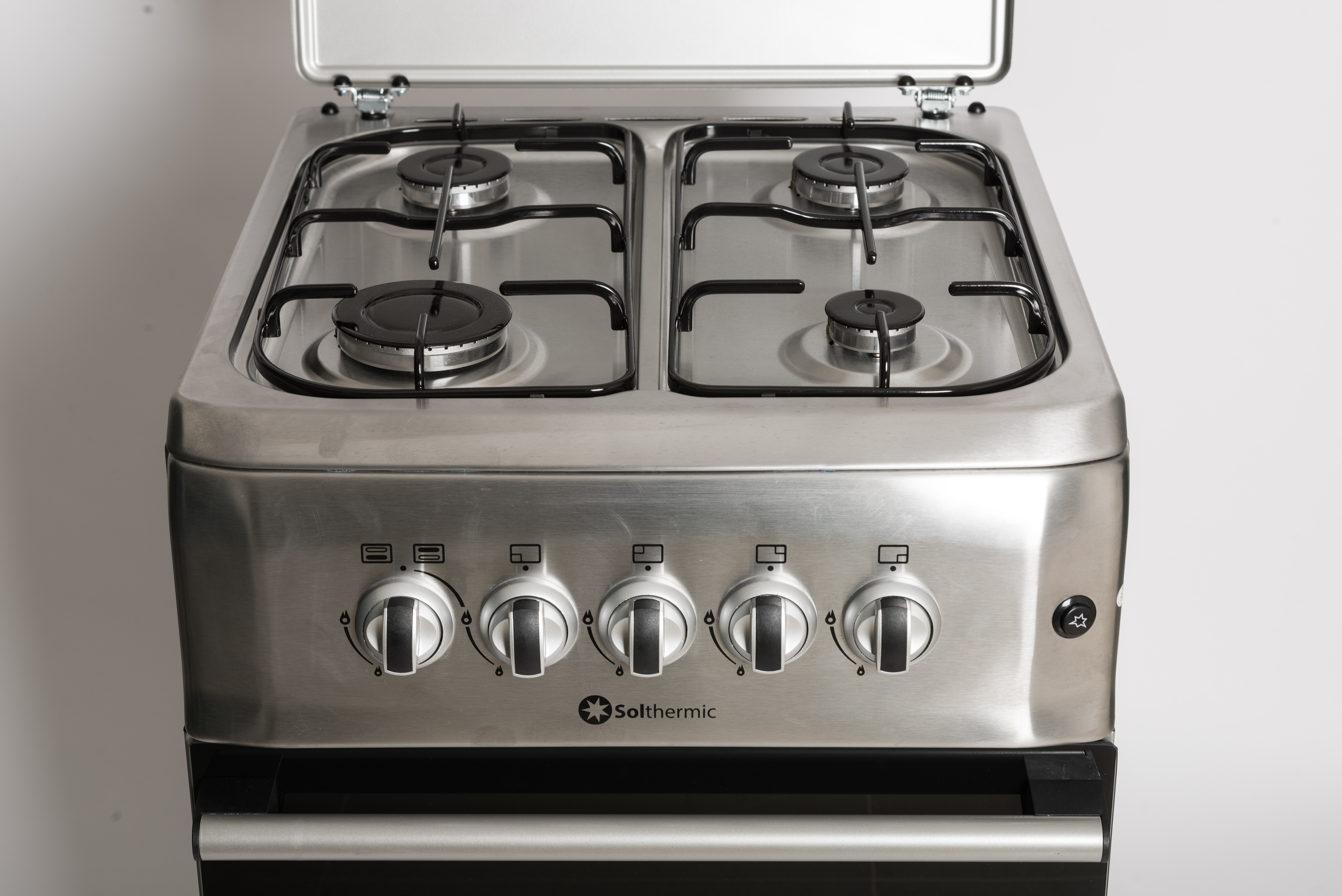 Vista superior de una cocina de gas de acero inoxidable con cuatro quemadores y perillas.