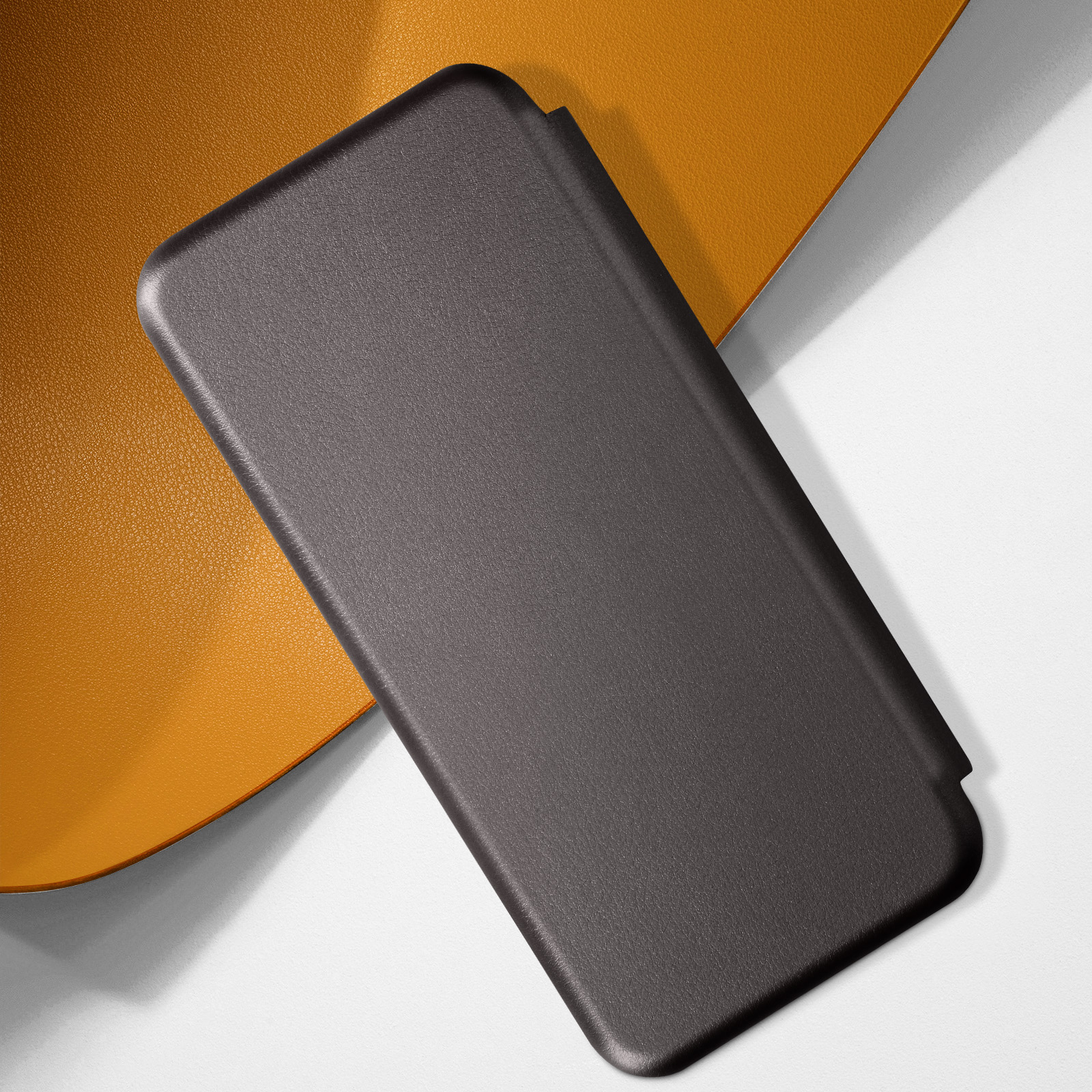 Custodia per telefono nera su superficie arancione, con sfondo bianco, primo piano.