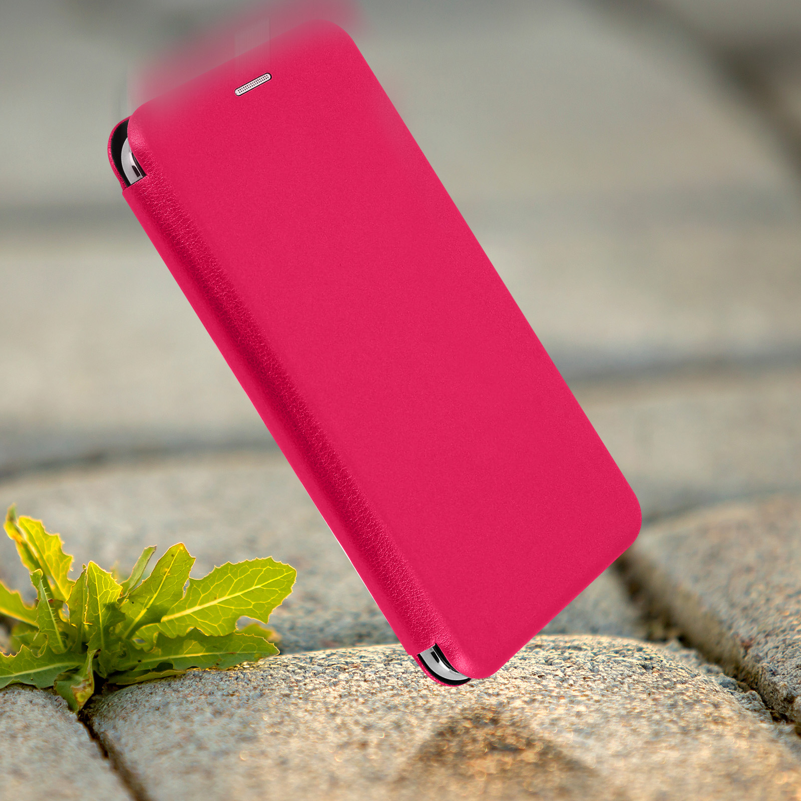 Custodia per telefono rosa che cade verso un sentiero di pietra con foglie verdi.