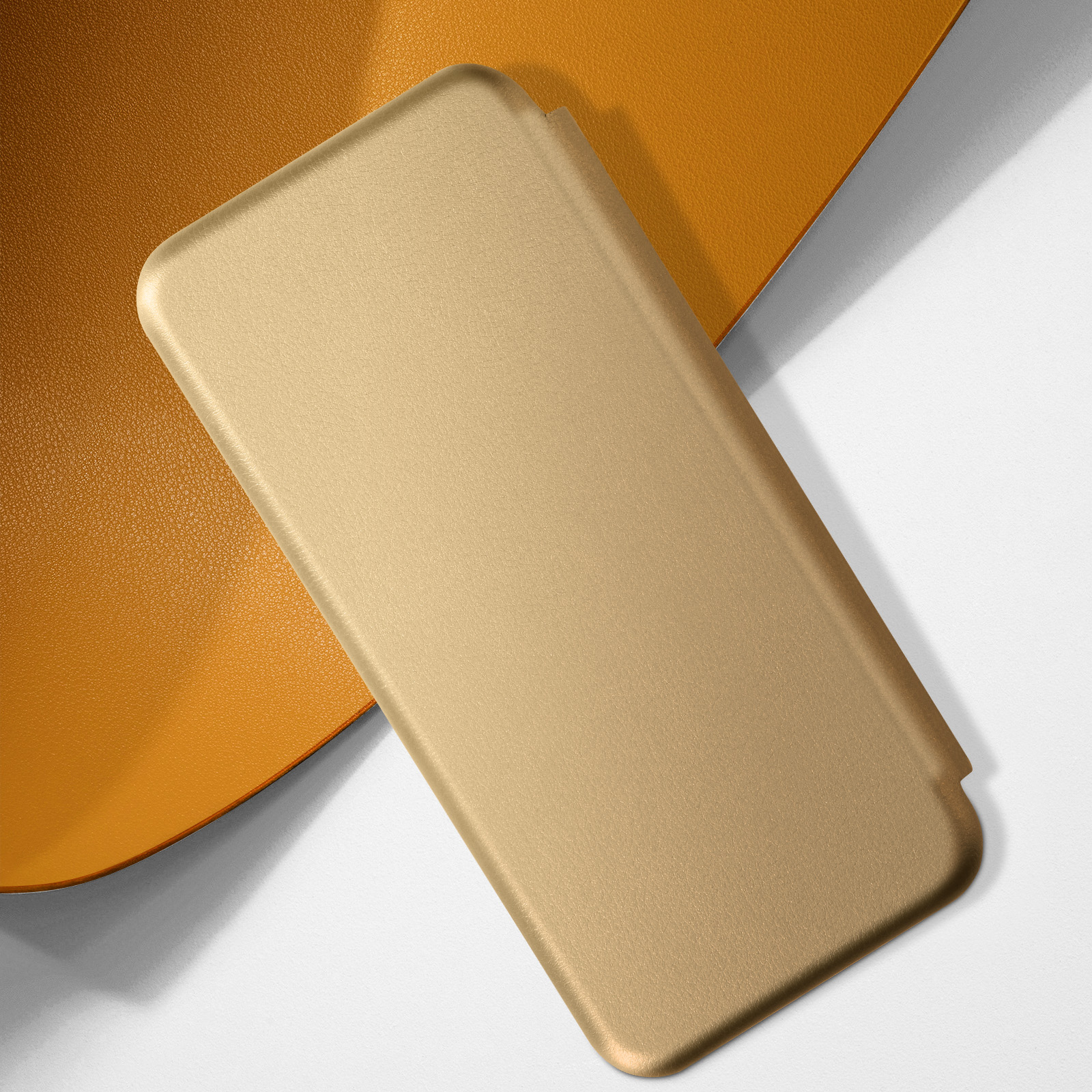 Una custodia dorata per telefono su una superficie bianca con uno sfondo giallo-arancio.