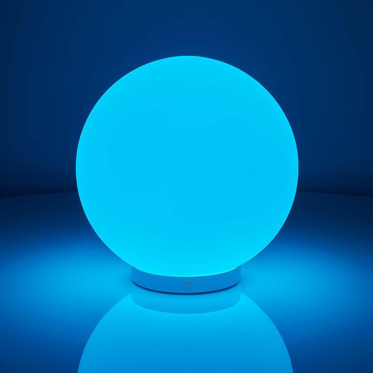 Sfera blu luminosa su base bianca, luce blu su sfondo blu.