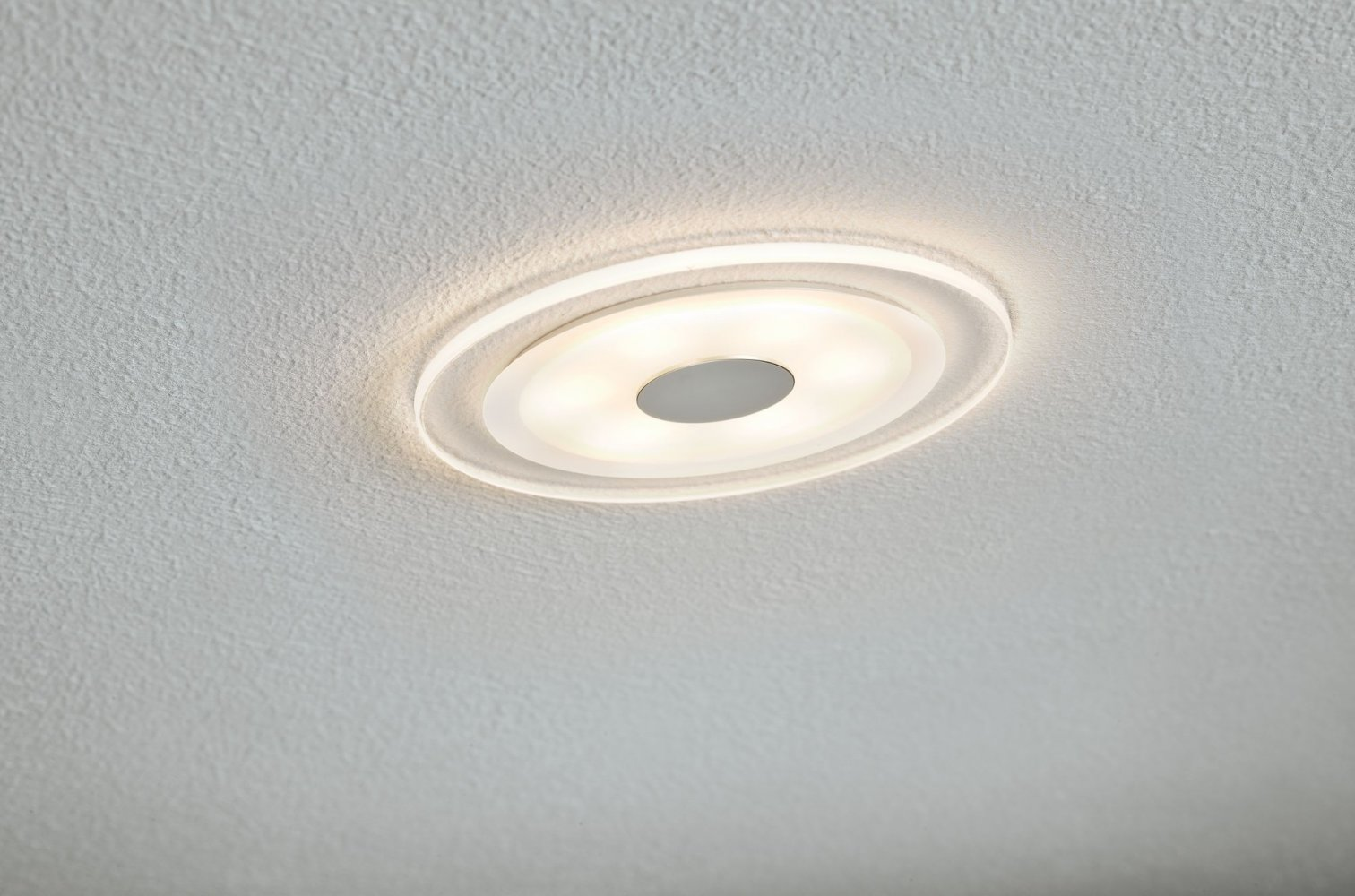 Un luminaire encastré au plafond, circulaire avec plusieurs sources lumineuses.