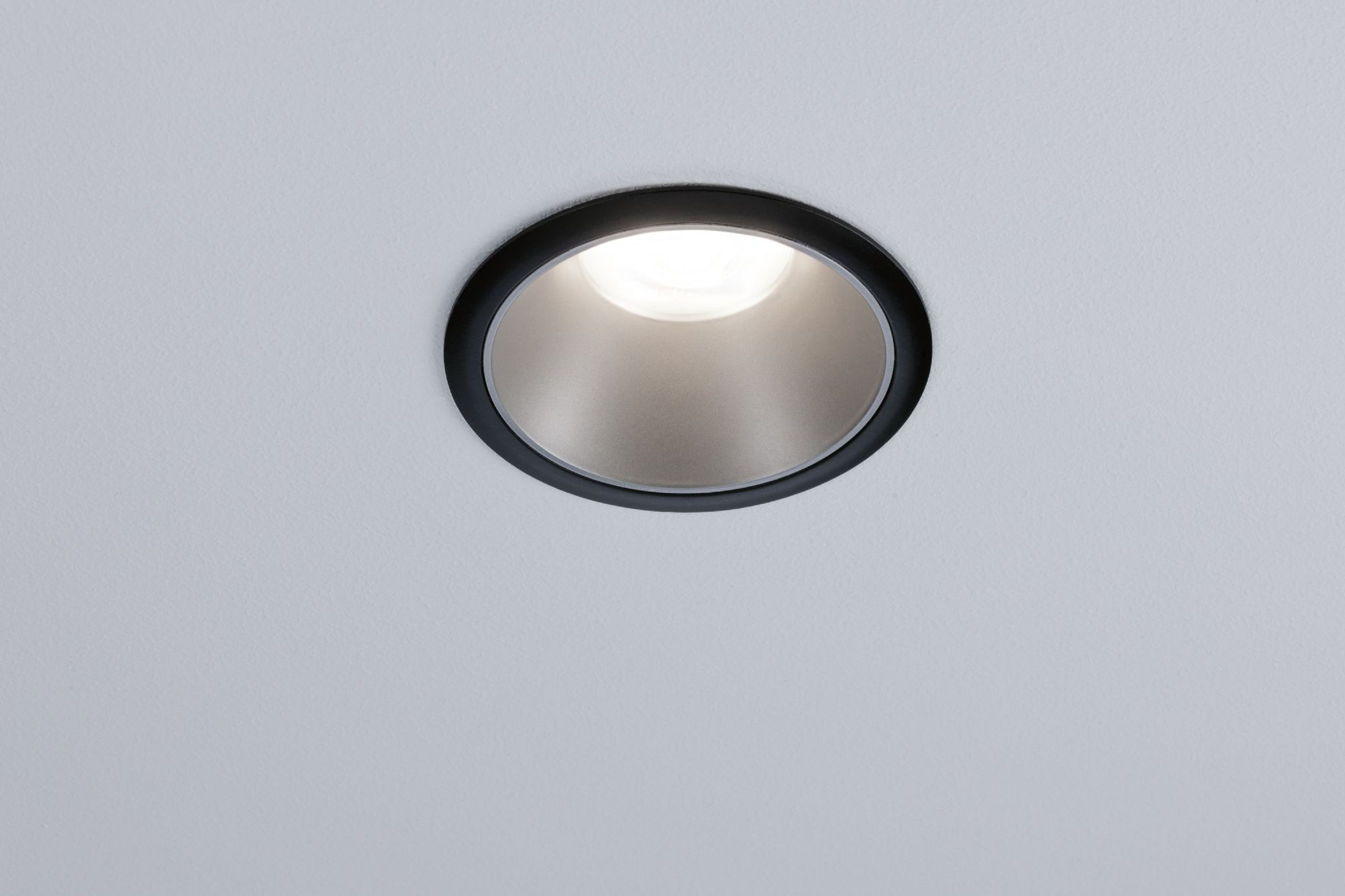 Faretto da soffitto a incasso, finitura nera, che emette luce in un soffitto bianco.