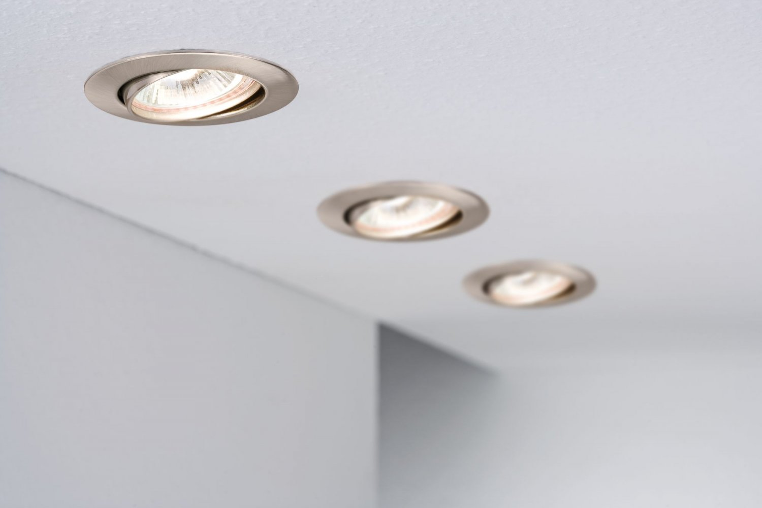 Tre faretti da soffitto incassati sono accesi.