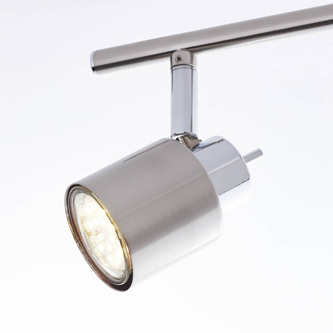 Ein moderner silberner Strahler mit LED-Licht auf weißem Hintergrund.