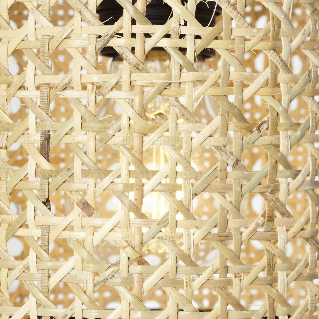 Nahaufnahme eines Lampenschirms aus geflochtenem Rattan mit Glühbirne.